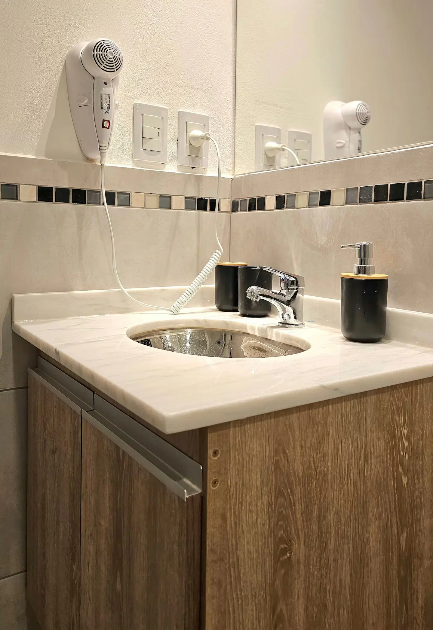 Baño con bacha de mármol y secador de pelo