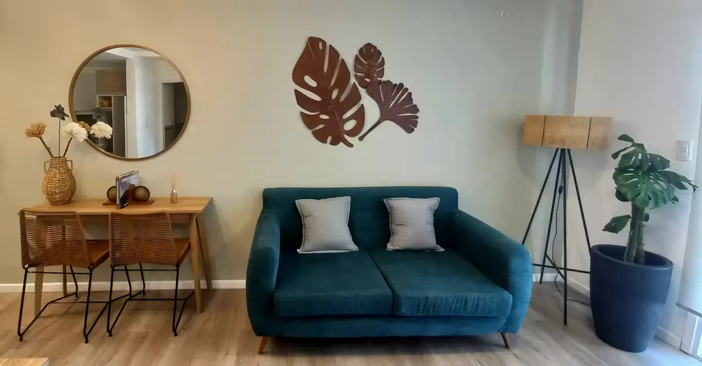 Sala de estar con sillón verde, mesa de luz y decoración cálida